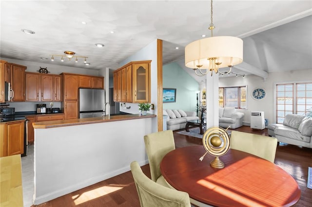 dining space featuring hardwood / wood-style flooring, a notable chandelier, and vaulted ceiling