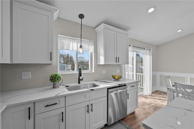 kitchen featuring dishwasher, sink, dark wood-type flooring, decorative light fixtures, and white cabinets