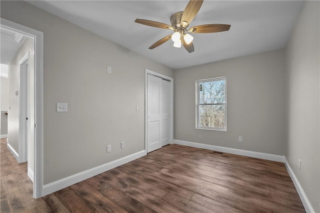 unfurnished bedroom featuring ceiling fan, a closet, and dark hardwood / wood-style floors