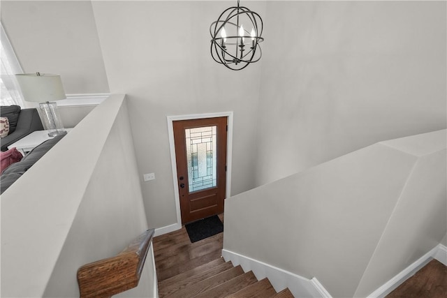 foyer featuring dark wood-type flooring and an inviting chandelier