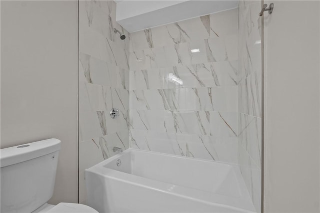 bathroom with tiled shower / bath combo and toilet