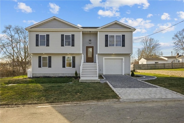 raised ranch with a front lawn and a garage