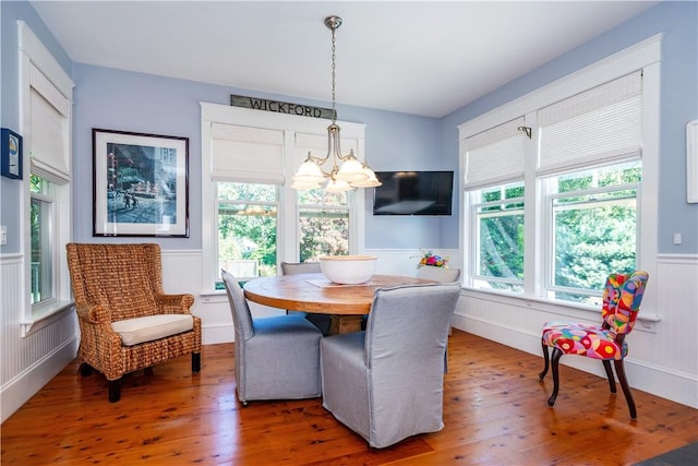 dining space with dark wood-type flooring and an inviting chandelier