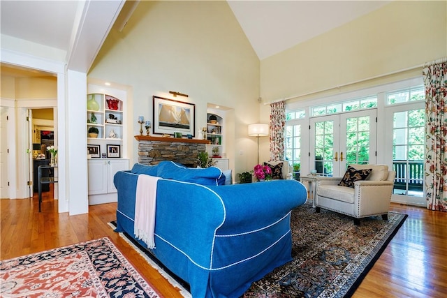 living room with hardwood / wood-style flooring, built in features, a fireplace, and french doors