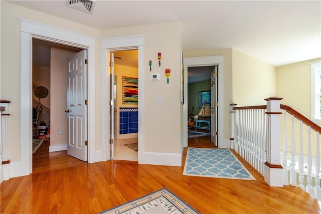 corridor with hardwood / wood-style flooring