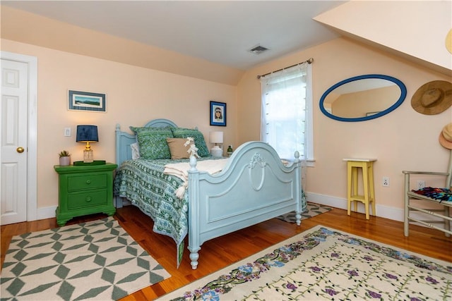 bedroom featuring vaulted ceiling and hardwood / wood-style flooring