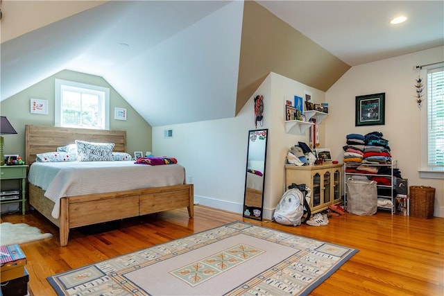 bedroom with lofted ceiling and wood-type flooring