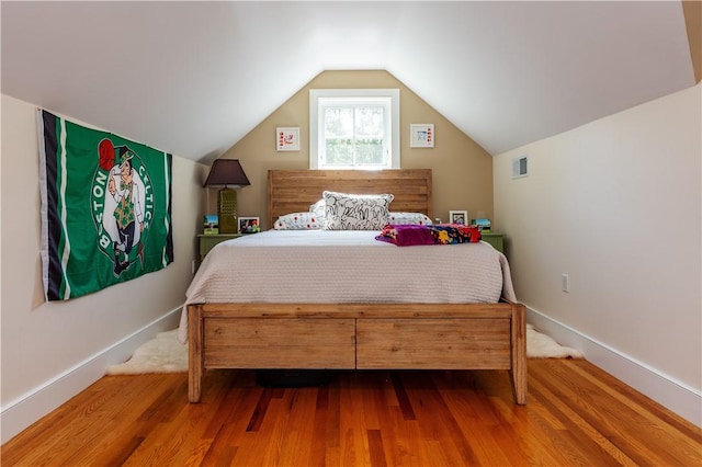 bedroom featuring hardwood / wood-style floors and lofted ceiling