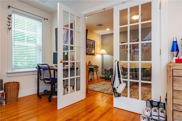 office with a wealth of natural light, french doors, and wood-type flooring