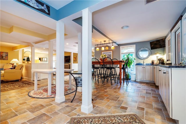 dining room with track lighting and ornate columns