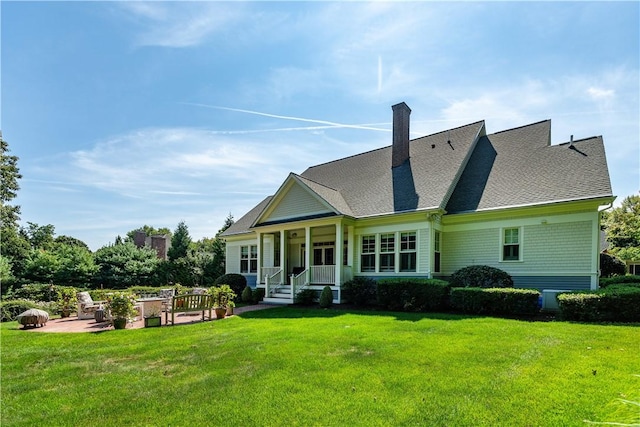 back of house featuring a lawn and a patio area