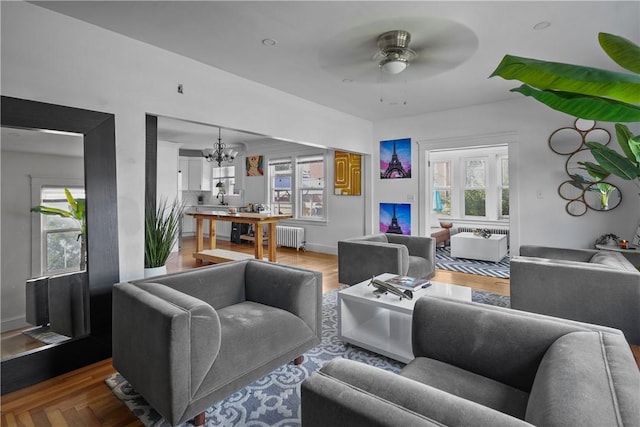 living room with ceiling fan with notable chandelier and radiator heating unit