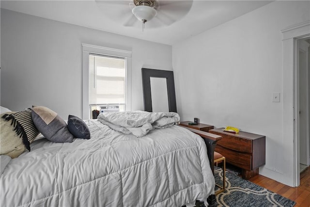 bedroom with light hardwood / wood-style floors, ceiling fan, and cooling unit