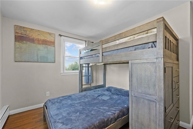 bedroom with a baseboard radiator and dark wood-type flooring