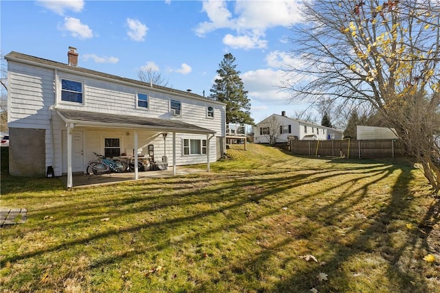 rear view of property with a patio and a lawn