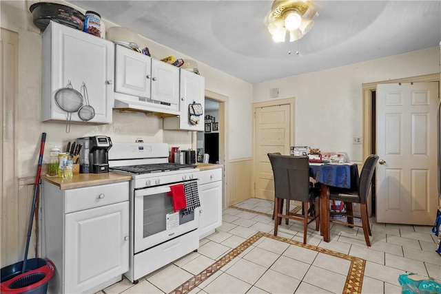 kitchen with light tile patterned flooring, ceiling fan, white cabinets, and white range with gas stovetop