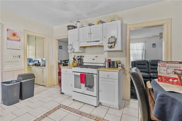 kitchen featuring electric range, ceiling fan, white cabinetry, and light tile patterned floors