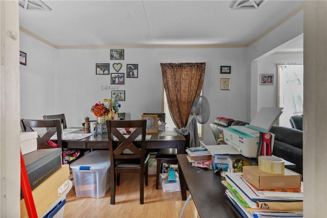 dining room with ornamental molding and light wood-type flooring