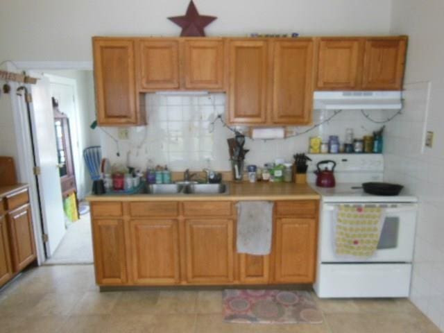 kitchen with decorative backsplash, electric range, and sink