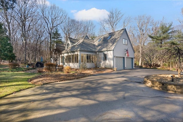 view of property exterior with a sunroom and a garage