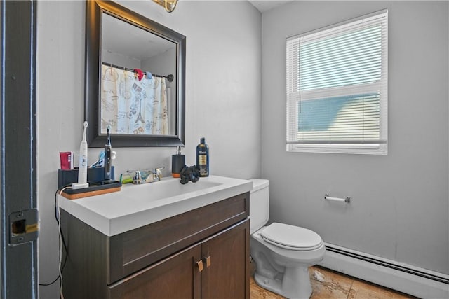 bathroom with plenty of natural light, toilet, vanity, and a baseboard heating unit