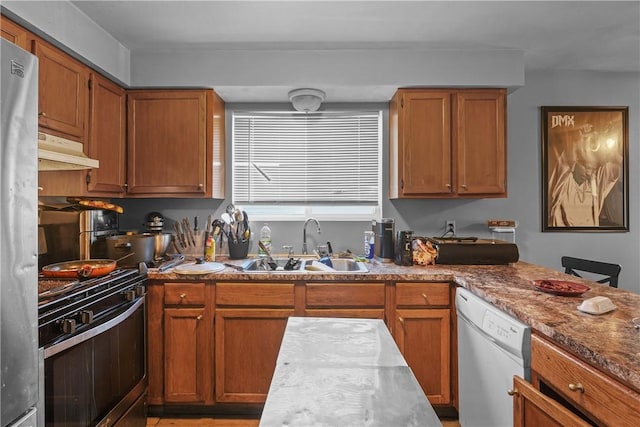 kitchen with light stone counters, sink, and appliances with stainless steel finishes