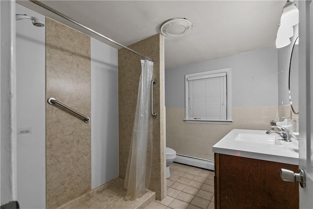 bathroom with vanity, tile patterned floors, baseboard heating, walk in shower, and tile walls