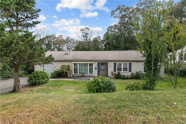 single story home with a garage and a front lawn