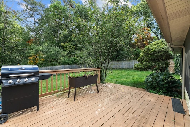 wooden terrace featuring area for grilling and a yard