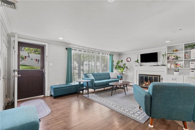 living room with wood-type flooring and ornamental molding