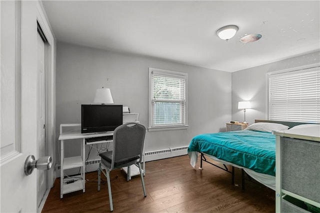 bedroom featuring a closet, dark hardwood / wood-style flooring, and a baseboard heating unit