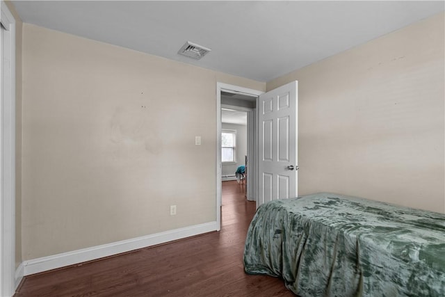 bedroom featuring dark hardwood / wood-style flooring and a baseboard radiator