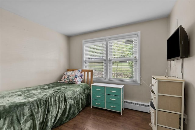 bedroom featuring dark wood-type flooring and a baseboard heating unit