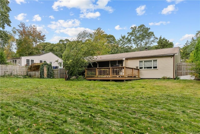 back of house featuring a lawn and a deck