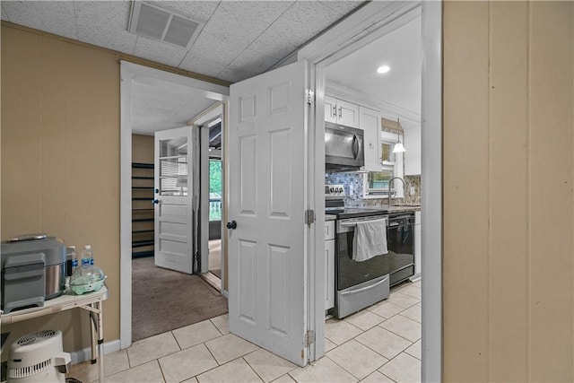 kitchen featuring backsplash, light colored carpet, sink, dishwasher, and stainless steel electric range oven