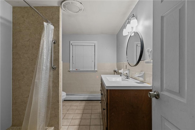 bathroom featuring vanity, a baseboard heating unit, tile patterned floors, toilet, and tile walls