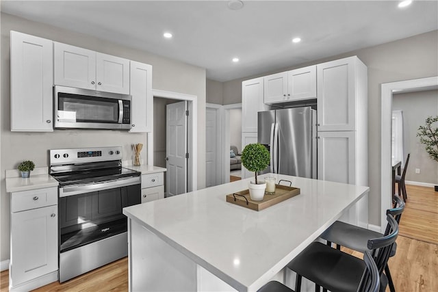 kitchen with white cabinetry, a center island, and appliances with stainless steel finishes