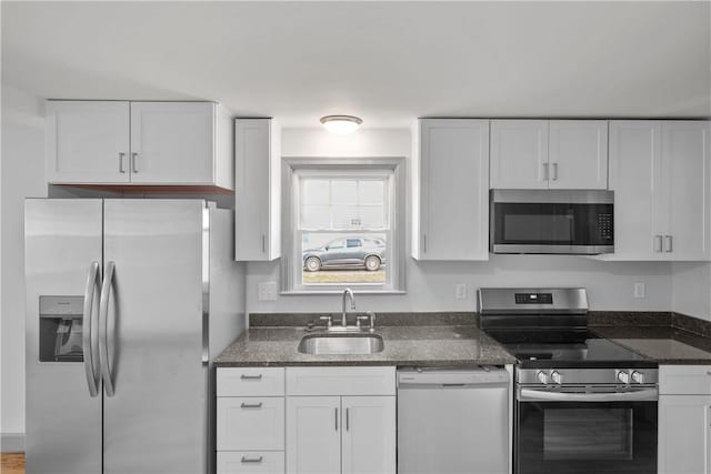 kitchen with sink, white cabinets, dark stone counters, and appliances with stainless steel finishes