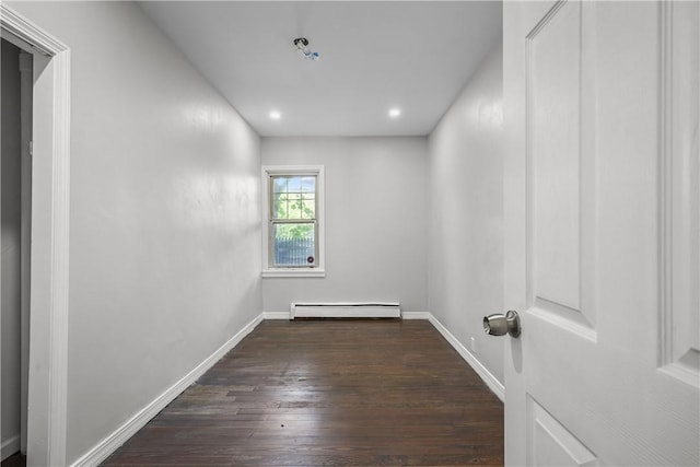 spare room with dark hardwood / wood-style floors and a baseboard radiator