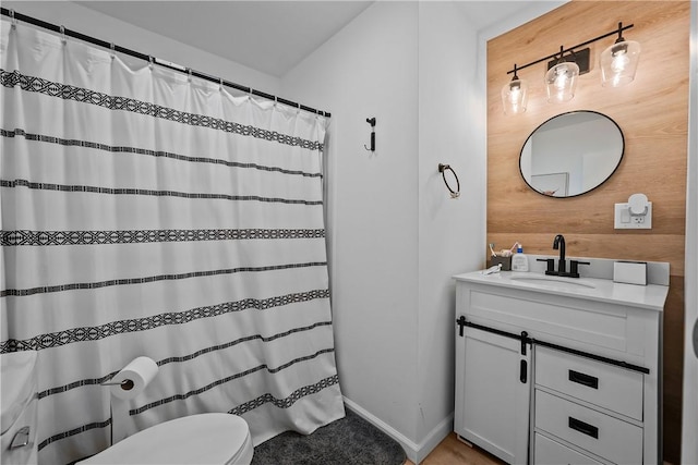 bathroom with vanity, toilet, and wood walls