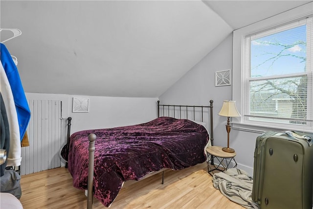 bedroom featuring vaulted ceiling and light wood-type flooring