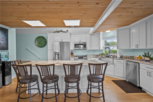 kitchen featuring wooden ceiling, sink, a center island, and stainless steel appliances