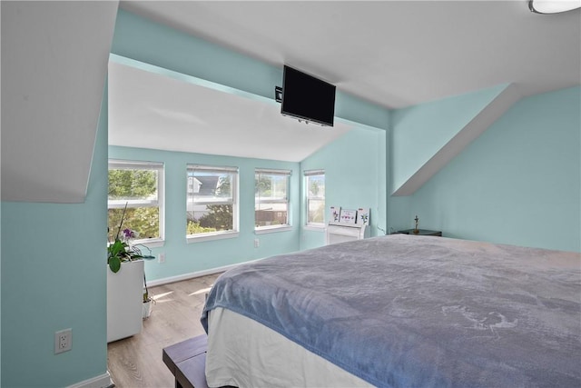 bedroom featuring light hardwood / wood-style floors and vaulted ceiling