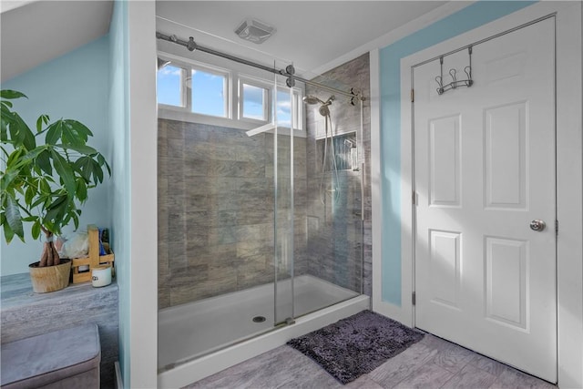 bathroom with wood-type flooring and a shower with shower door