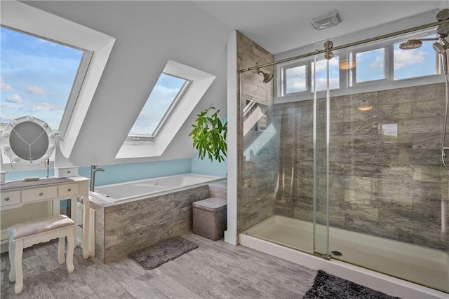 bathroom featuring wood-type flooring, a skylight, and separate shower and tub