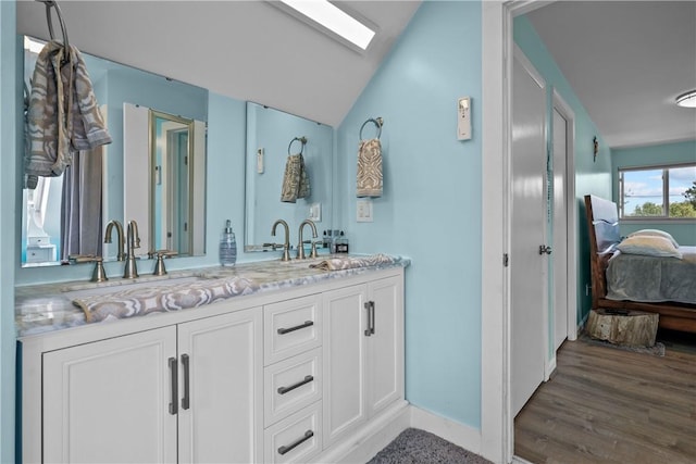 bathroom featuring hardwood / wood-style floors, vanity, and vaulted ceiling