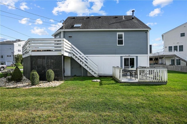 rear view of house with a yard and a wooden deck