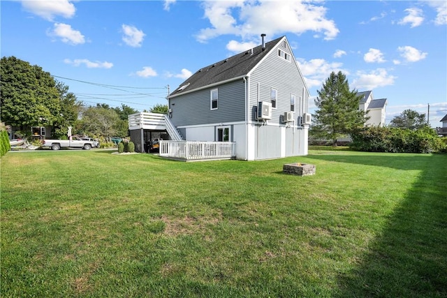 rear view of property featuring a lawn and a wooden deck