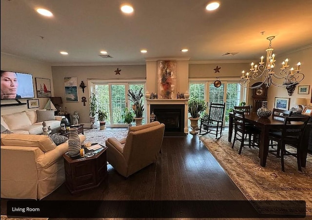 living room featuring dark hardwood / wood-style flooring, a wealth of natural light, a fireplace, and an inviting chandelier