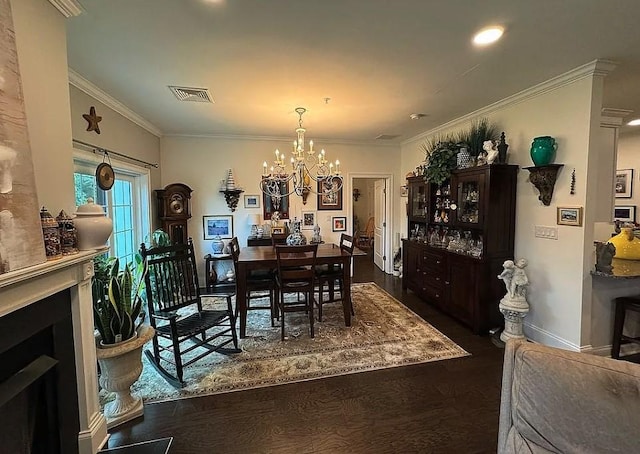 dining area featuring a fireplace, crown molding, dark wood-type flooring, and a chandelier